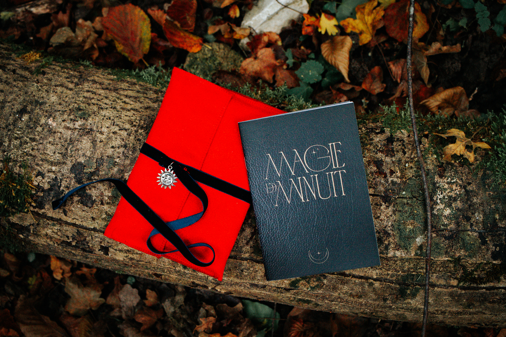 Pochette rouge avec le livret dans les bois
